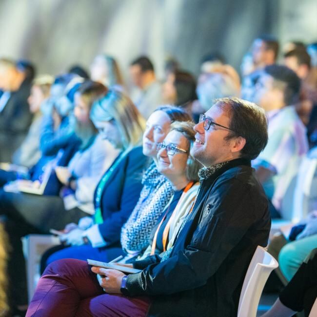 Engaged audience members looking at the stage.